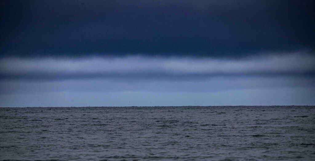 A large body of water under a cloudy sky