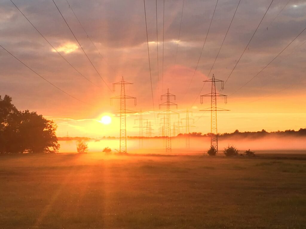 Low angle photography of electric post near fogs